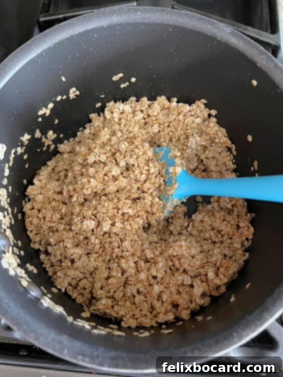 Oats, butter, brown sugar, and vanilla cooking in a saucepan on the stovetop.