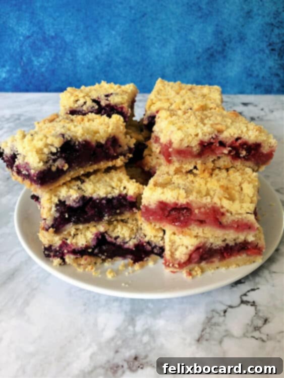 Star Spangled Berry Crumble Bars 3 Stack of freshly baked berry crumble bars, with a blue version on the left and a red version on the right, showcasing the patriotic colors.