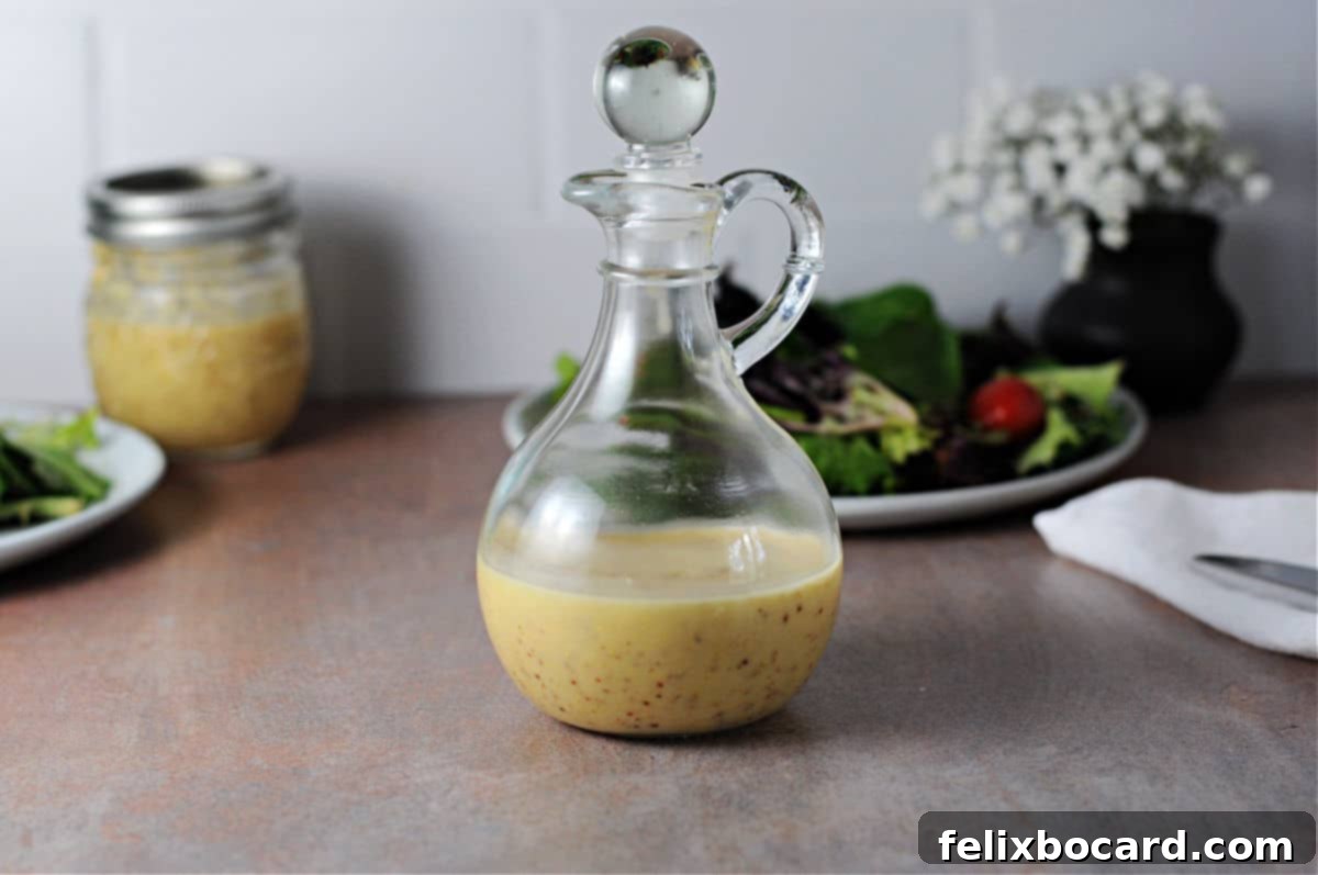 A elegant cruet filled with freshly made red wine shallot vinaigrette, placed on a rustic wooden surface with blurred salad greens in the background, ready to be served.