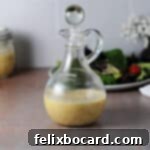 A cruet of red wine shallot vinaigrette, showcasing its rich color and inviting texture.