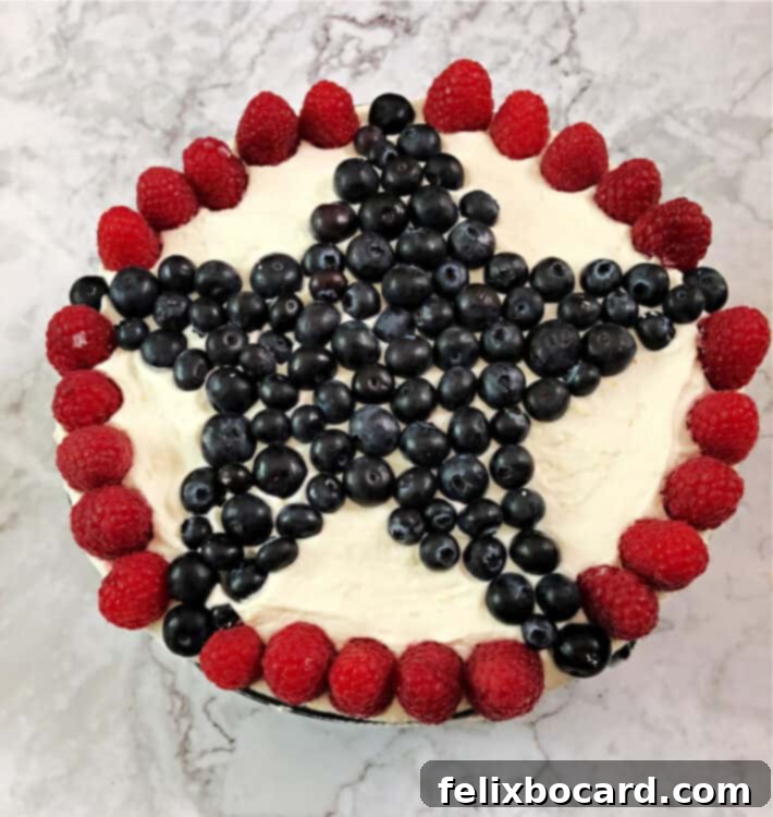 top view of decorated torte with large star made of blueberries surrounded by a circle of raspberries