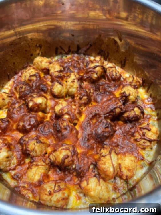 cooked tater tots and cheese on top of the casserole in the instant pot