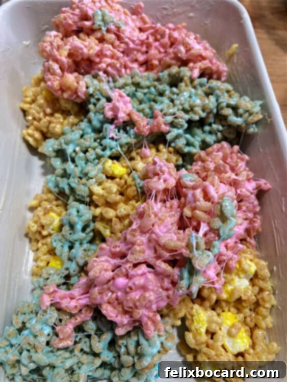 3 colors of peeps rice krispie treat mixture placed in a greased dish.