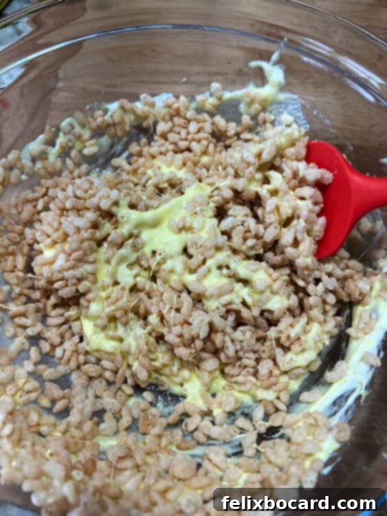 mixing cereal with the marshmallow mixture.