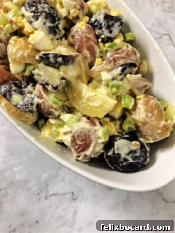 Red, white, and blue potato salad served in a decorative bowl, ready for a patriotic holiday.