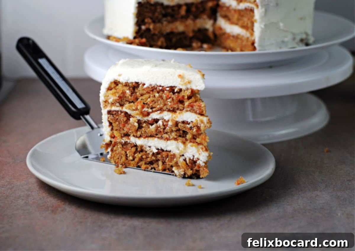 A slice of layered carrot cake served on a small plate.