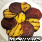 slices of grilled red and golden beets in an overlapping circle on a plate