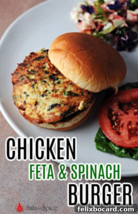 A vibrant and appetizing Pinterest pin featuring a grilled chicken feta and spinach burger on a bun, accompanied by fresh vegetables, designed to attract viewers to the recipe.