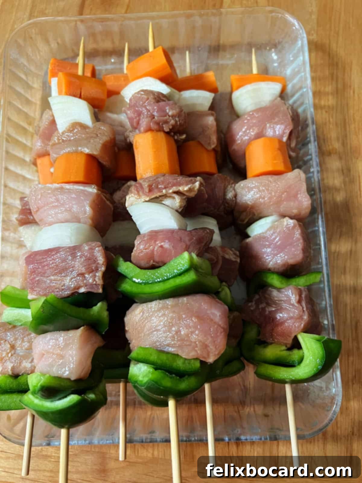 Skewers loaded with alternating pork and vegetables, ready for grilling.