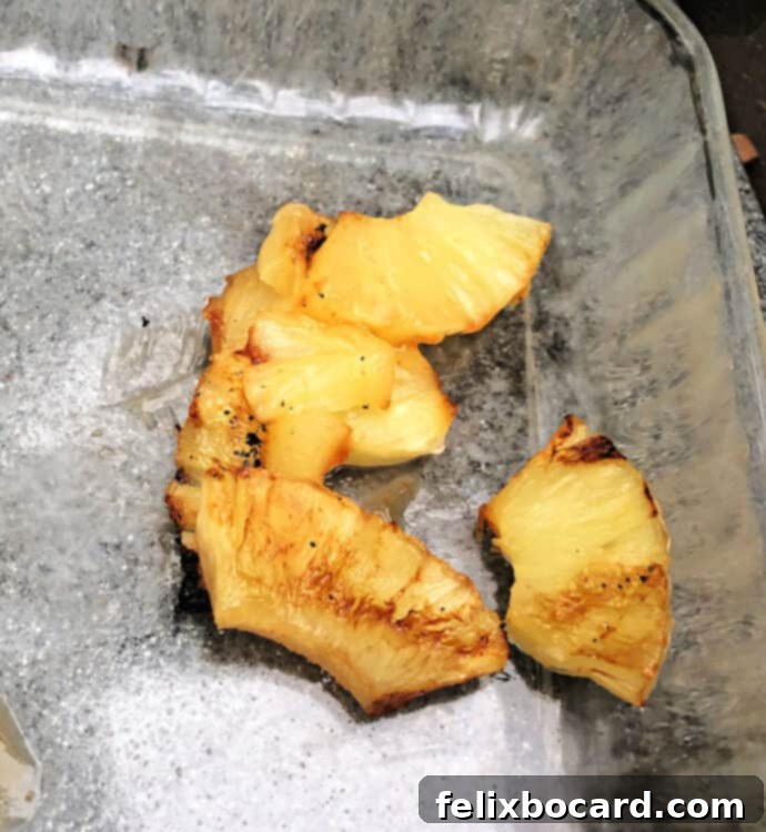 Chunks of grilled pineapple falling apart in a glass pan, illustrating the problem.