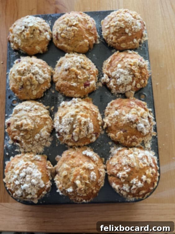 A muffin tin filled with 12 baked strawberry and yogurt muffins, golden brown.