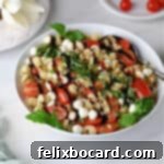 Caprese pasta salad drizzled with balsamic glaze and ready to serve.