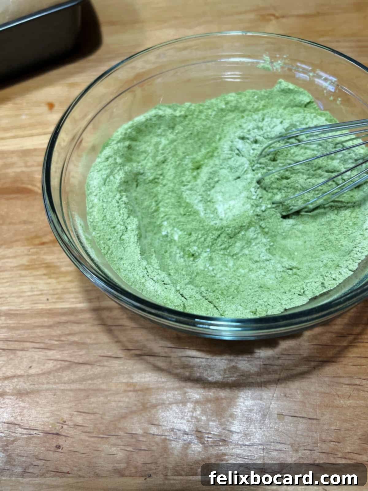 dry ingredients with matcha powder mixed in a bowl.