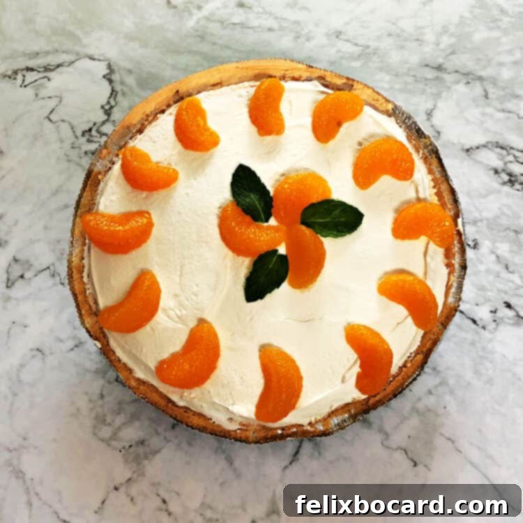 Top-down view of a beautifully decorated orange Creamsicle pie, garnished with fresh mandarin orange slices, ready to be served.