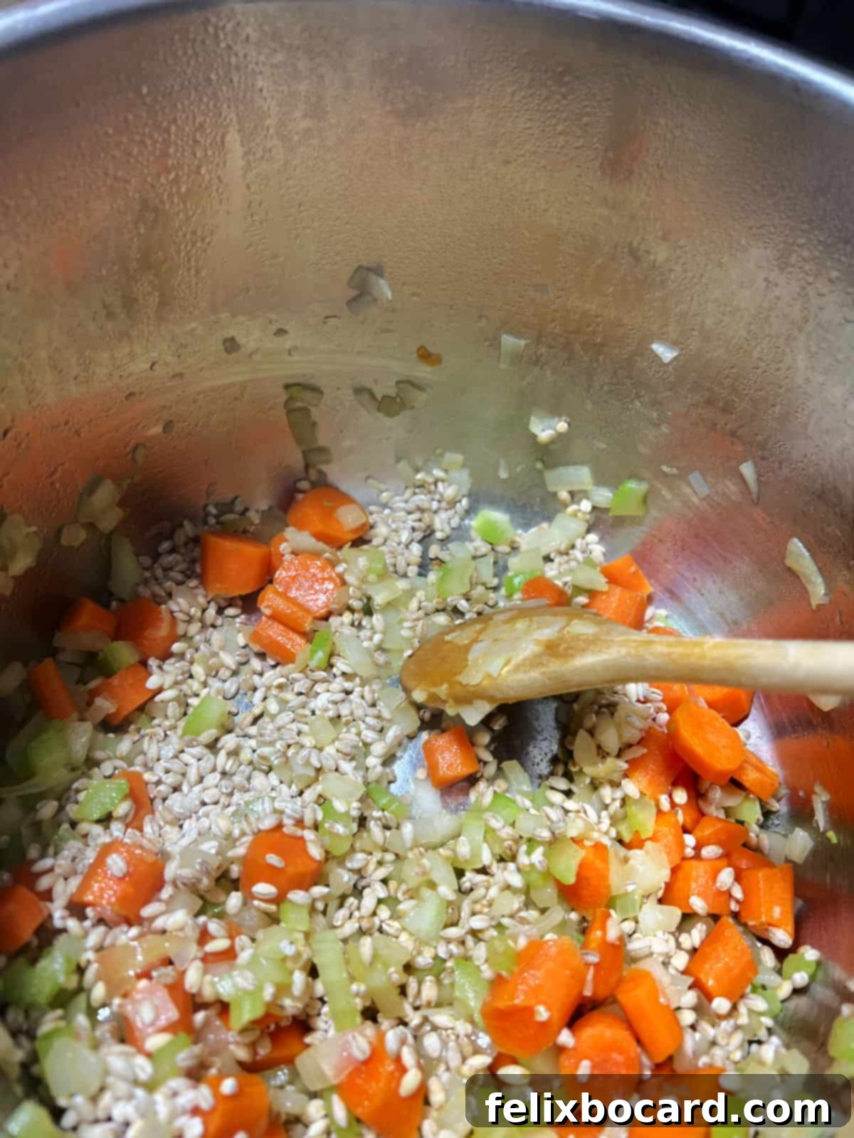 Sautéing the vegetables and garlic in the Instant Pot for chicken barley soup.