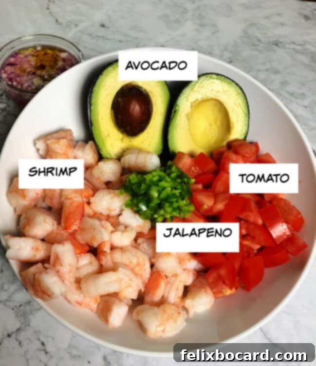ingredients in a bowl: cooked shrimp, avocado, tomato, chopped jalapeno