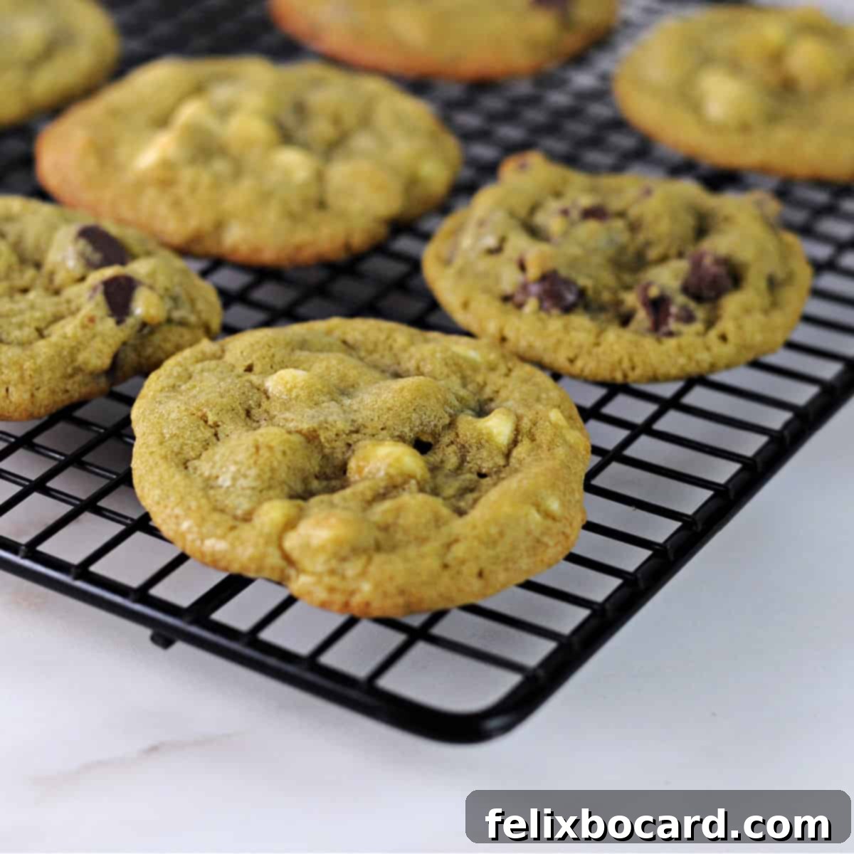 Close up of matcha chocolate chip cookies cooling on a wire rack.