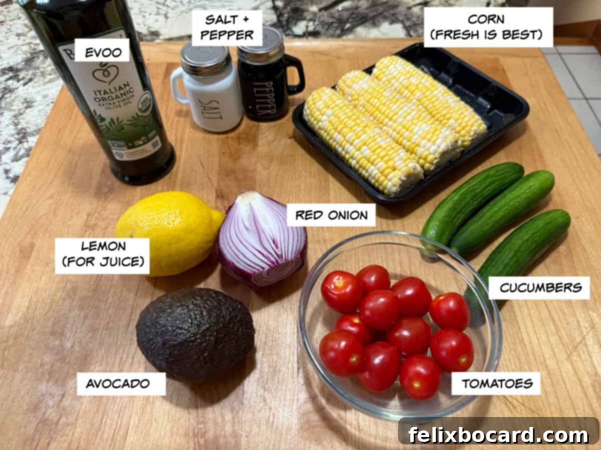 Fresh ingredients for corn tomato avocado salad including corn, avocado, tomatoes, red onion, and cucumber.