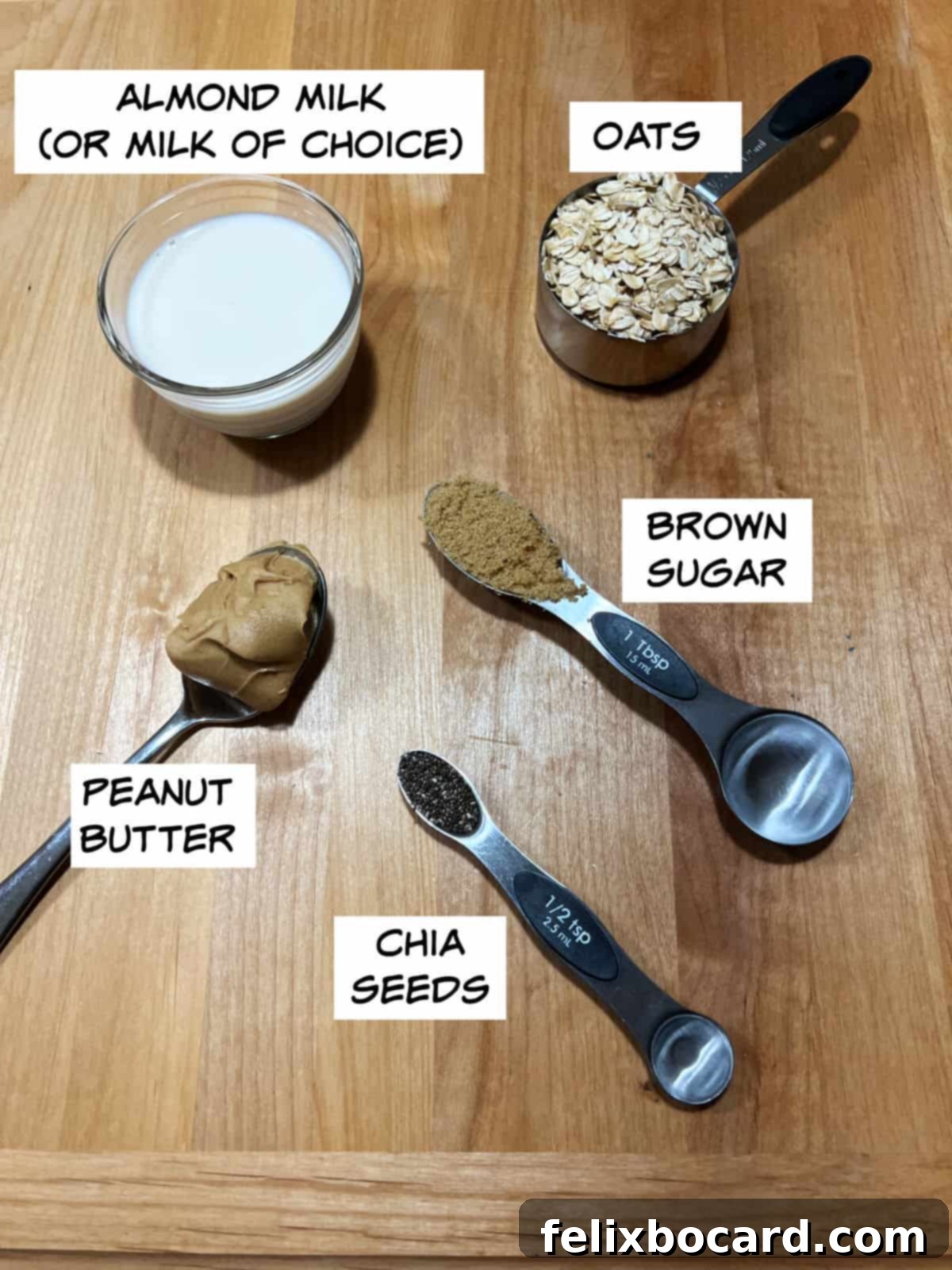 A selection of raw ingredients for making peanut butter overnight oats, including old-fashioned rolled oats, a carton of almond milk, creamy peanut butter, a bowl of brown sugar, and a small dish of chia seeds.