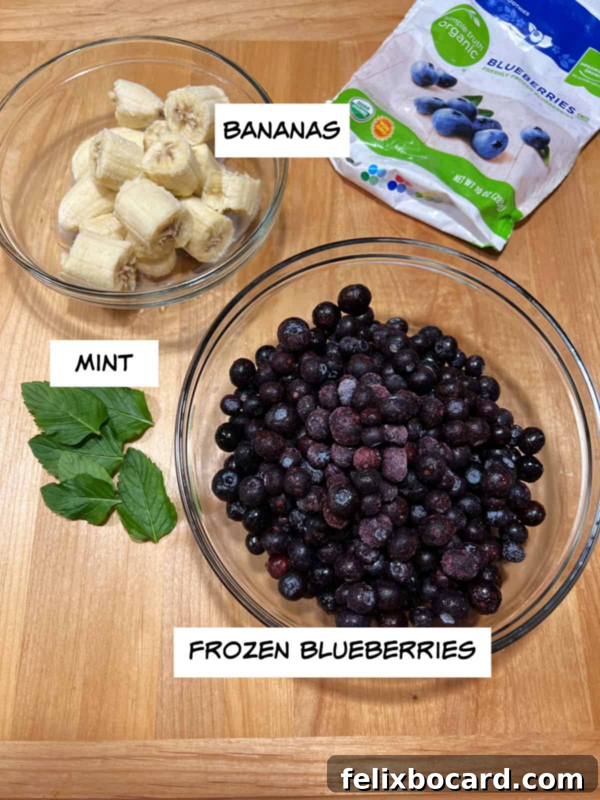 Key ingredients laid out: frozen blueberries, sliced frozen bananas, and fresh mint leaves, ready for blending.
