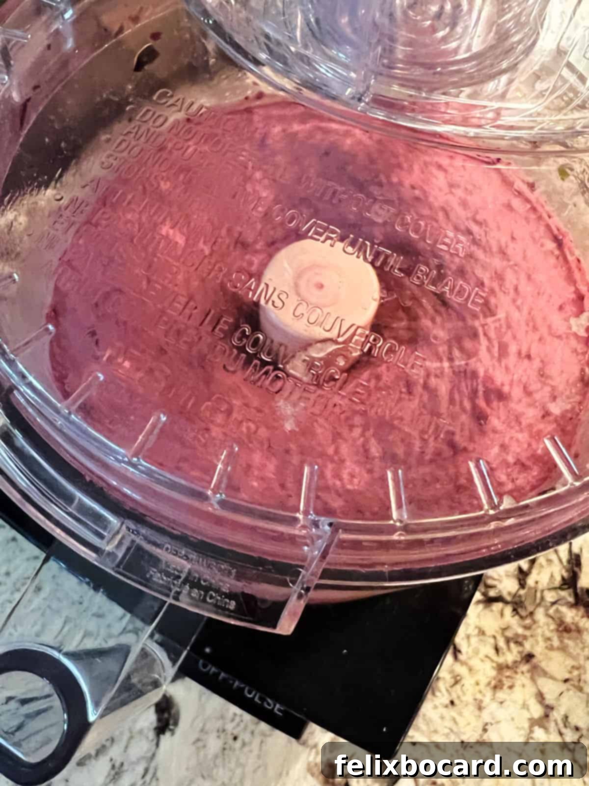 Close-up of creamy Blueberry Nice Cream being blended to perfection in a food processor, showcasing its smooth texture.