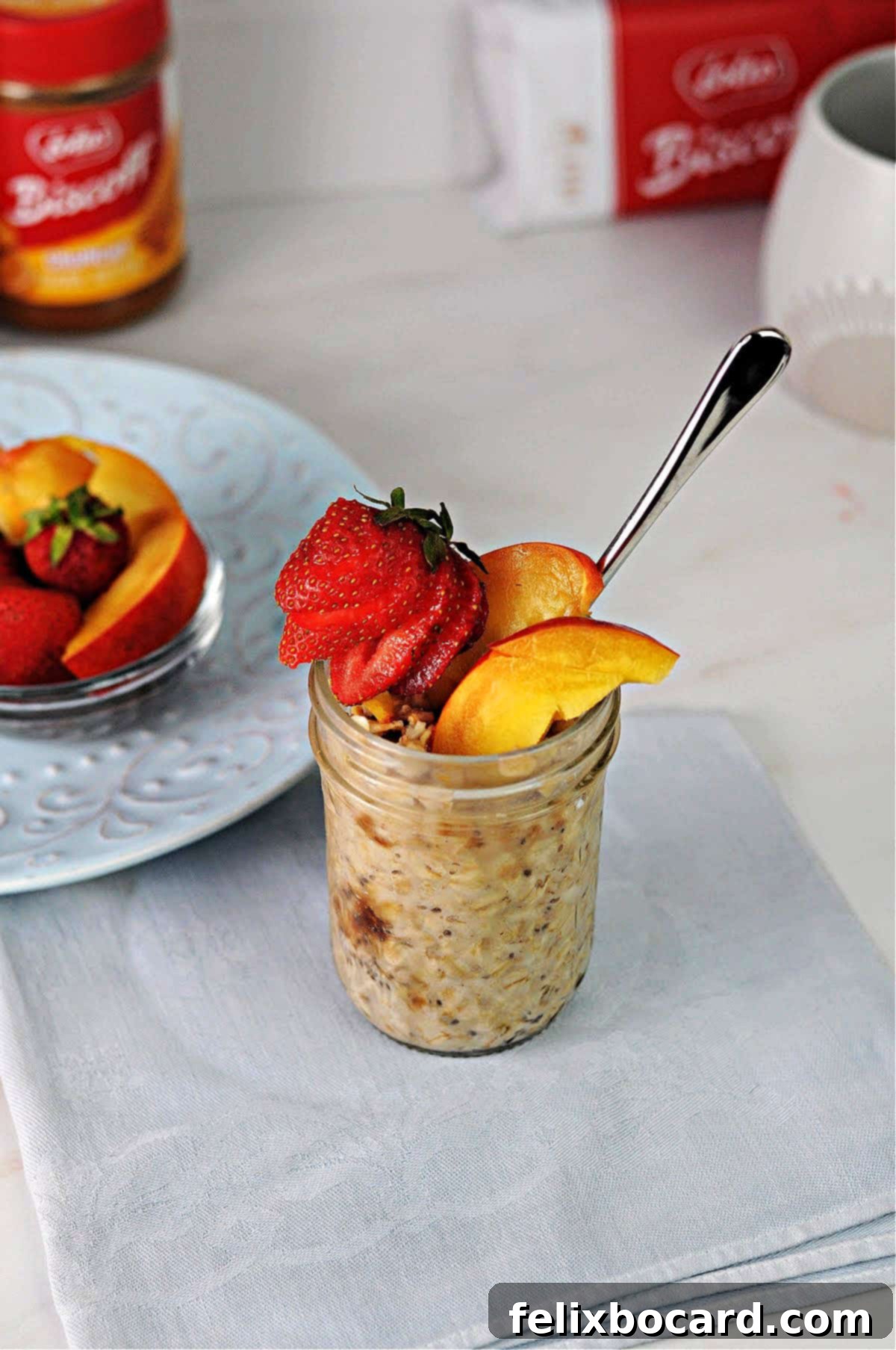 Biscoff overnight oats in a small jar garnished with fresh fruit like berries and nectarine slices.