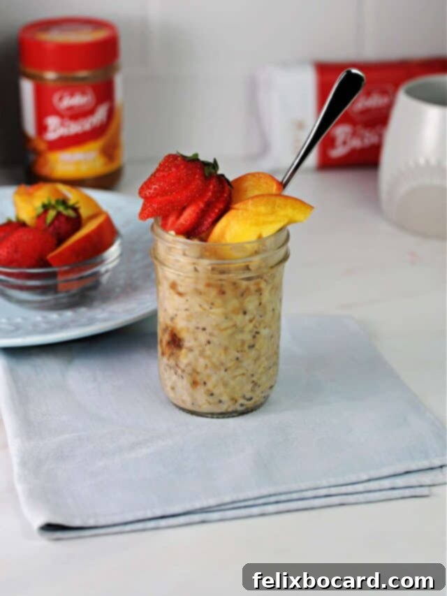 Close-up of Biscoff overnight oats in a jar with berries.