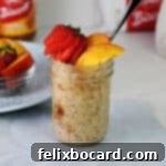 Biscoff overnight oats in a jar garnished with slices of nectarine and a strawberry.
