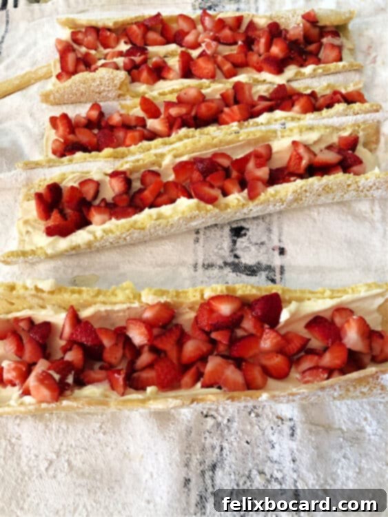 Strawberry Shortcake Swirl 3 Broken cake roll pieces being filled with strawberries and whipped cream filling