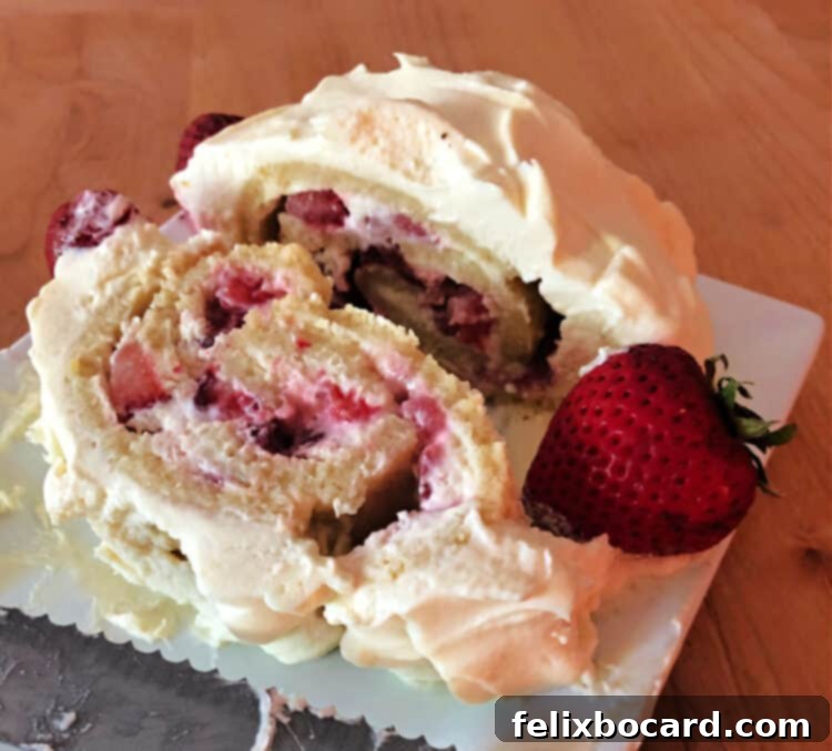 Strawberry Shortcake Swirl 7 A perfect slice of strawberry shortcake roll revealing layers of cake, whipped cream, and fresh strawberries