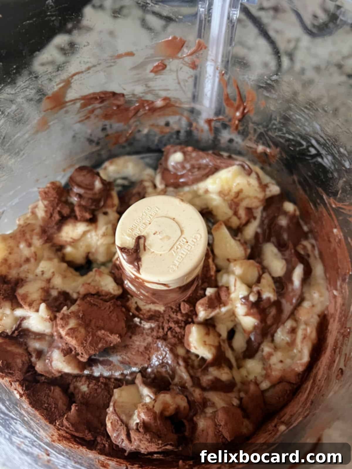 chocolate and banana ingredients partially mixed in a food processor.