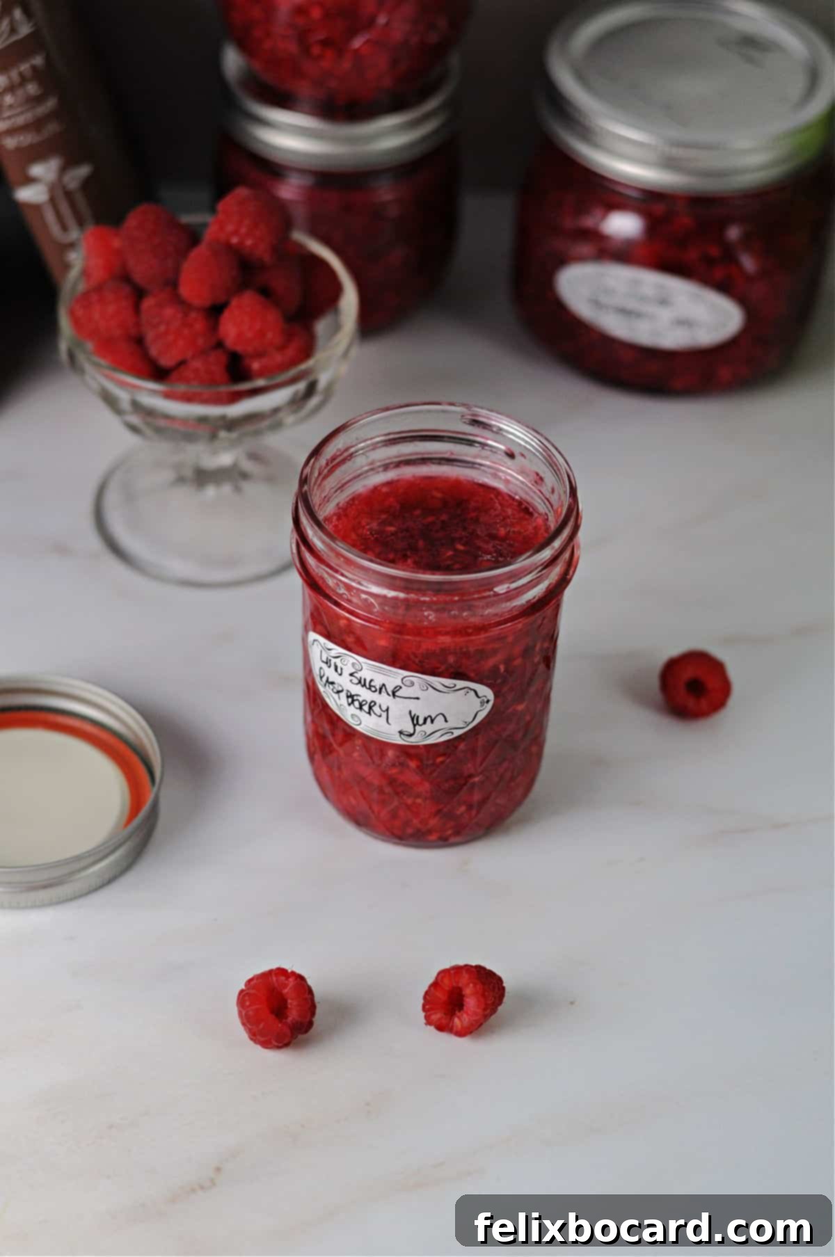 Homemade Reduced Sugar Raspberry Freezer Jam 2 angled view from above of a jar of low sugar raspberry freezer jam.