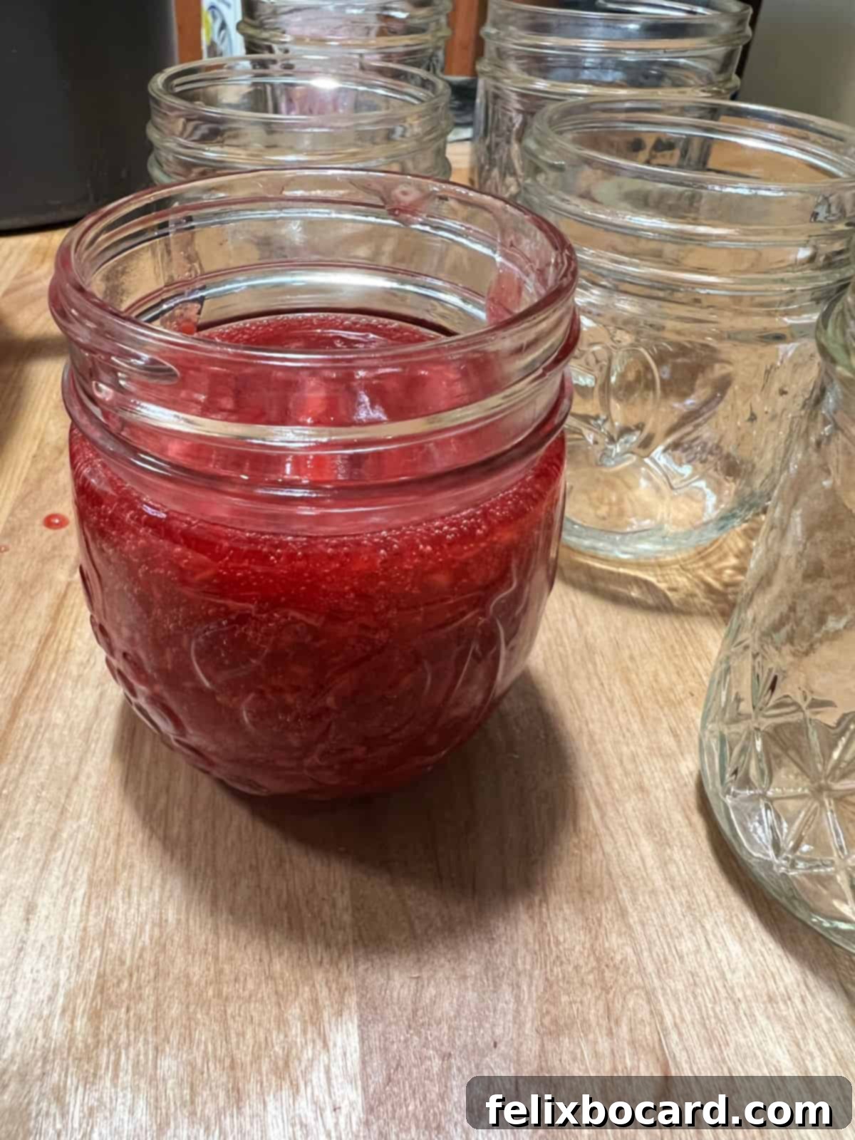 Homemade Reduced Sugar Raspberry Freezer Jam 6 jam placed in a jar with room left at the top for expansion.