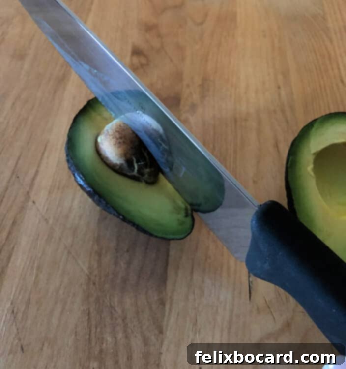 Safe method of removing an avocado pit using a cutting board