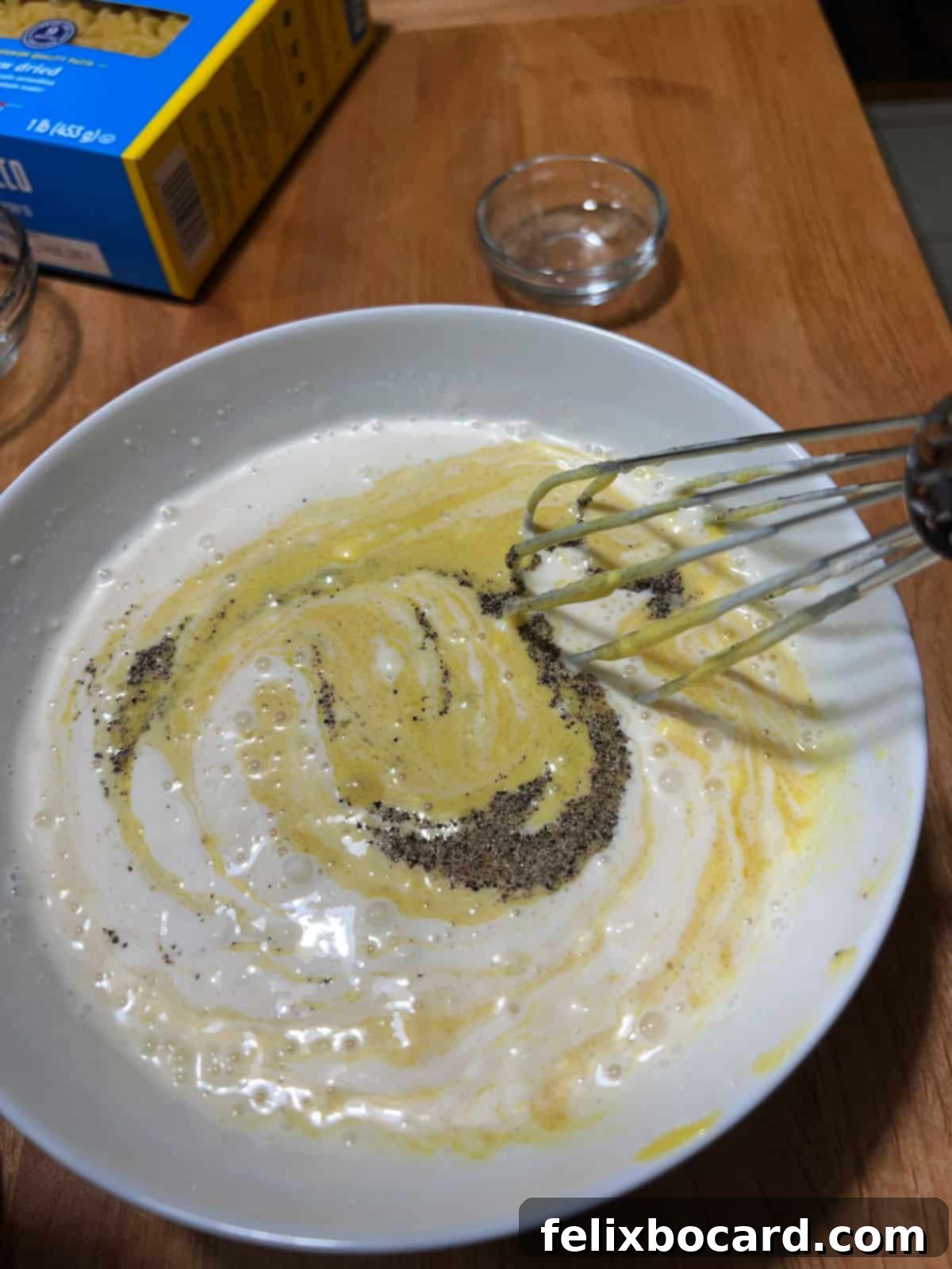 Irresistibly Sweet Macaroni Salad 5 whisking dressing together in a bowl.