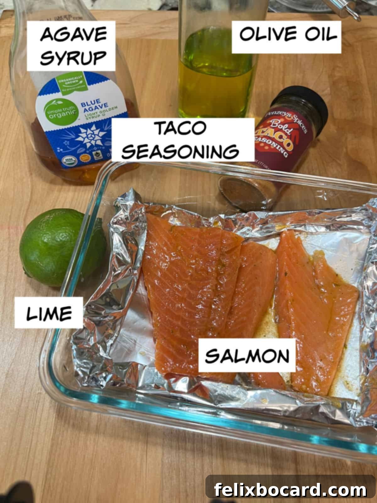 BBQ Salmon Tacos with Tangy Slaw 3 Close-up of fresh ingredients: agave syrup, olive oil, taco seasoning, a whole lime, and raw salmon fillets.
