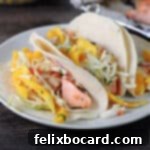BBQ Salmon Tacos with Tangy Slaw 7 bbq salmon tacos with mango slaw on a small plate