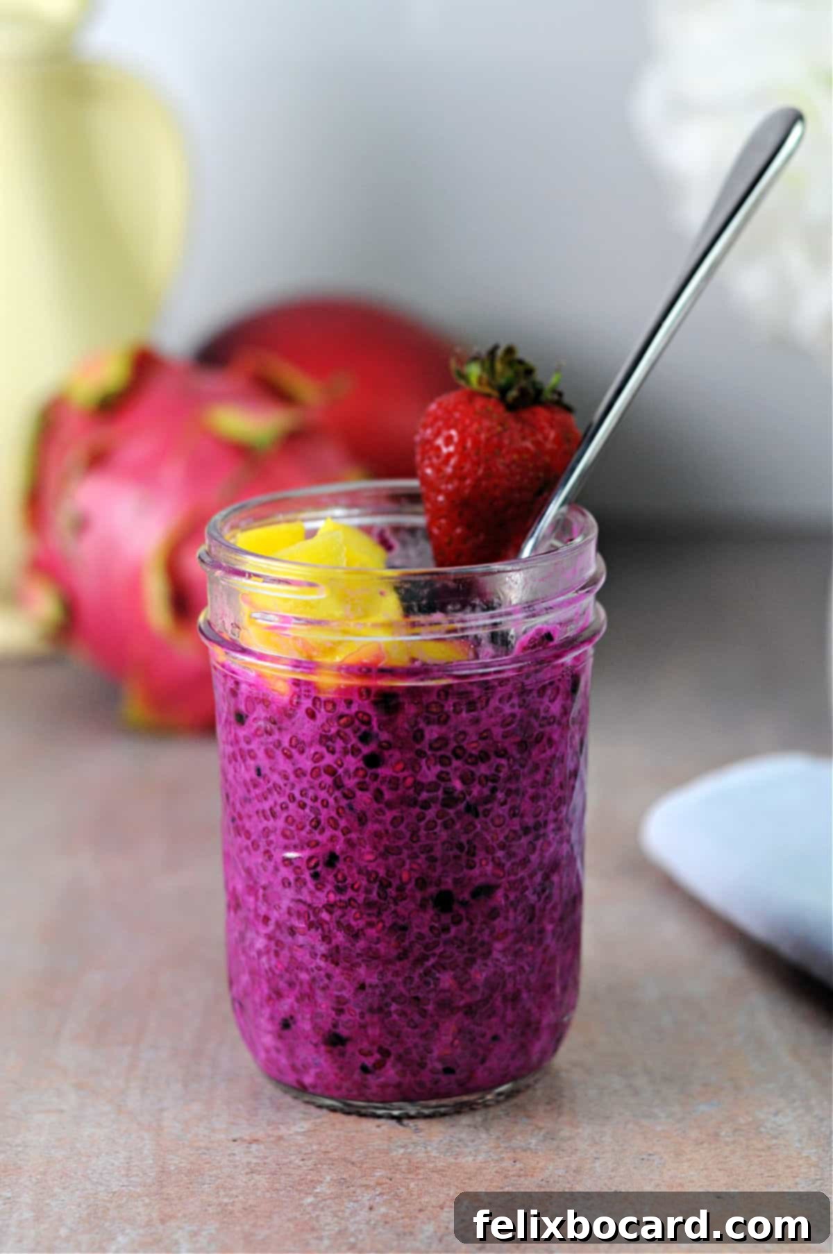 small jar of dragon fruit chia seed pudding garnished with fruit.