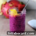 small jar of dragon fruit chia seed pudding garnished with fresh fruit.