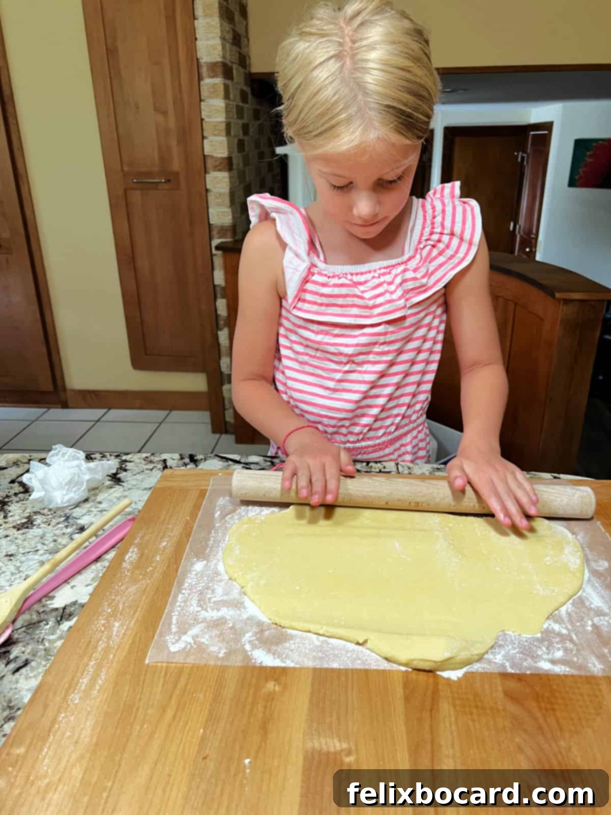 Rolling out sugar cookie dough on a floured surface.