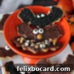 Three bat sugar cookies on a small orange dish, decorated and ready to eat.