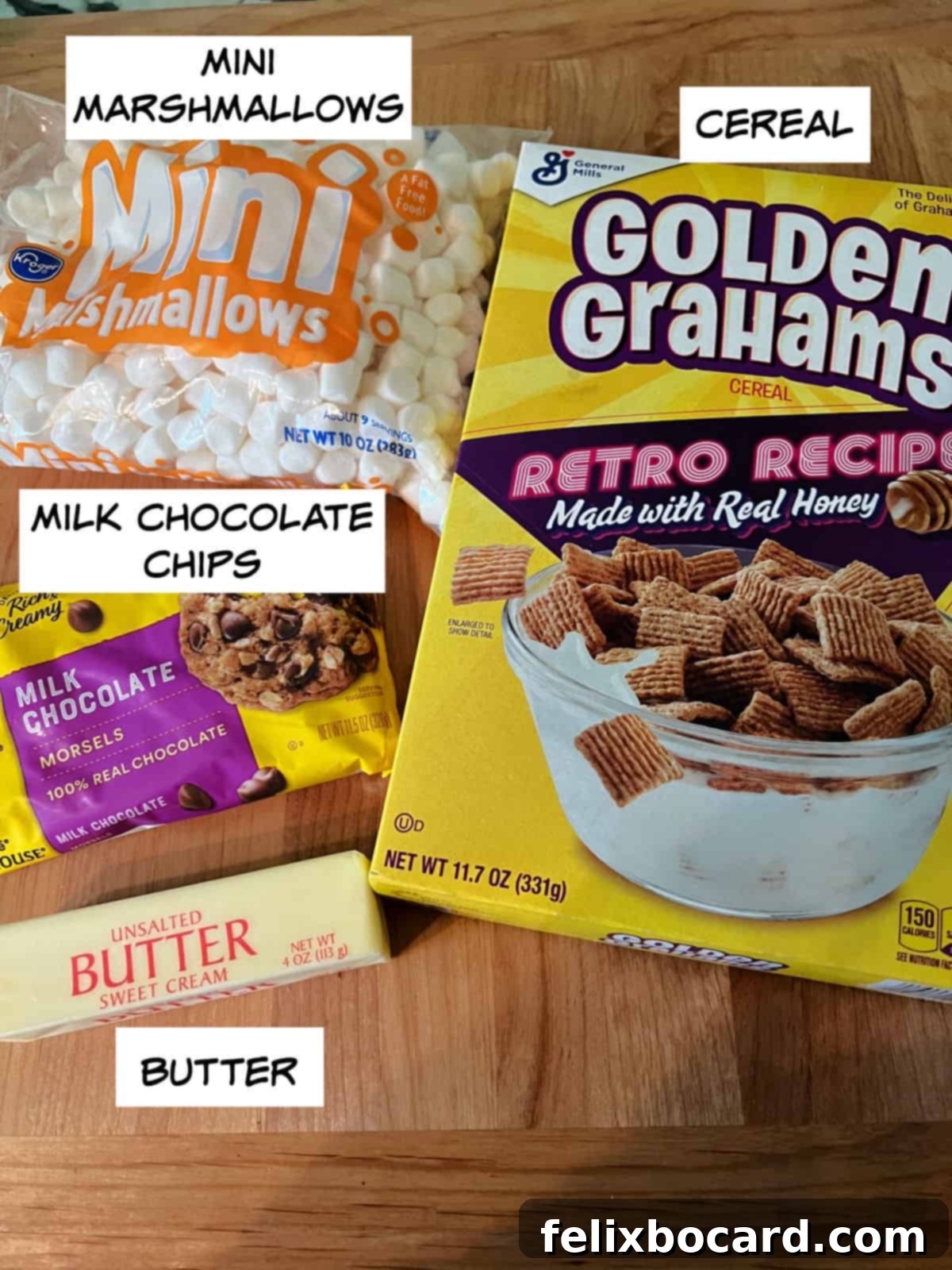 Various ingredients laid out for s'mores cookies: mini marshmallows, milk chocolate chips, graham cereal, and butter.