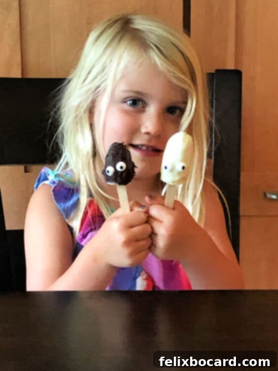 Child holding 2 banana pops