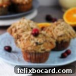 3 cranberry walnut muffins on a blue plate.