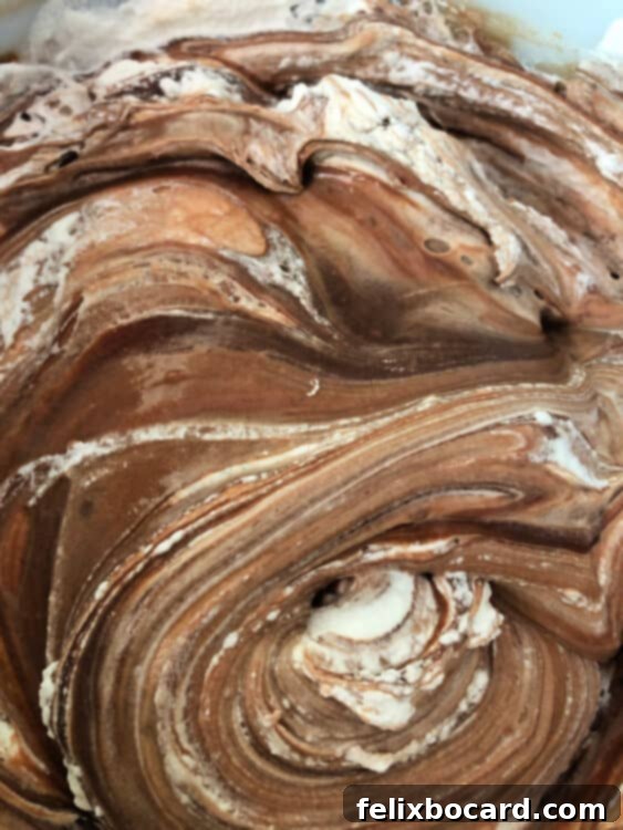 Frozen Campfire Pie 4 A close-up shot of rich chocolate mixture and fluffy whipped cream, gently swirled together in a bowl, creating a harmonious blend.