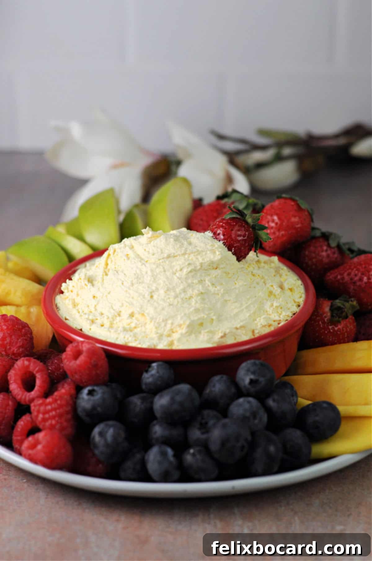 Sweet Cloud Fruit Dip 2 Creamy Cool Whip dip surrounded by an assortment of fresh fruits like strawberries, grapes, and pineapple chunks.