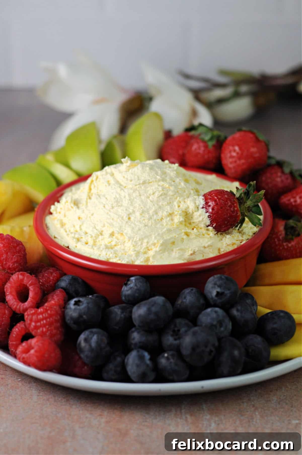 Sweet Cloud Fruit Dip 5 A vibrant fruit platter featuring a 2-ingredient fruit dip, surrounded by strawberries, grapes, pineapple, and mango slices.