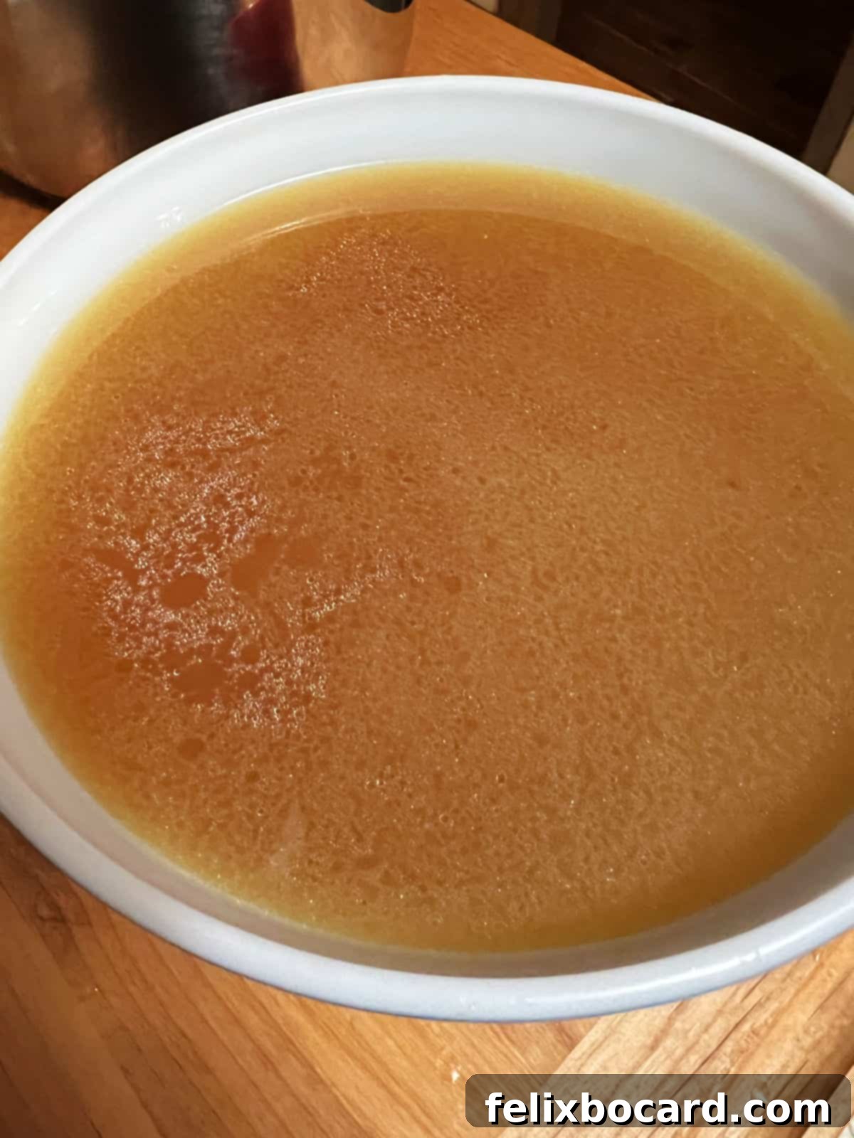 A steaming bowl of freshly made Instant Pot turkey bone broth, garnished with fresh herbs.