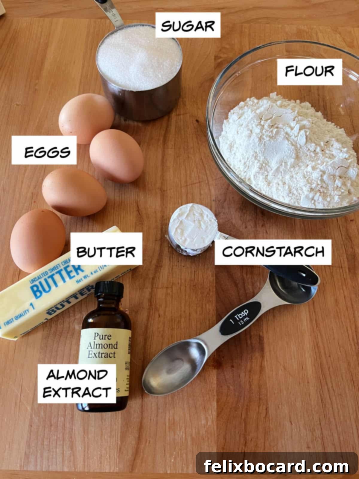 Norwegian Christmas Krumkake 3 Ingredients for Krumkake: eggs, flour, sugar, cornstarch, butter, and almond extract laid out on a surface.