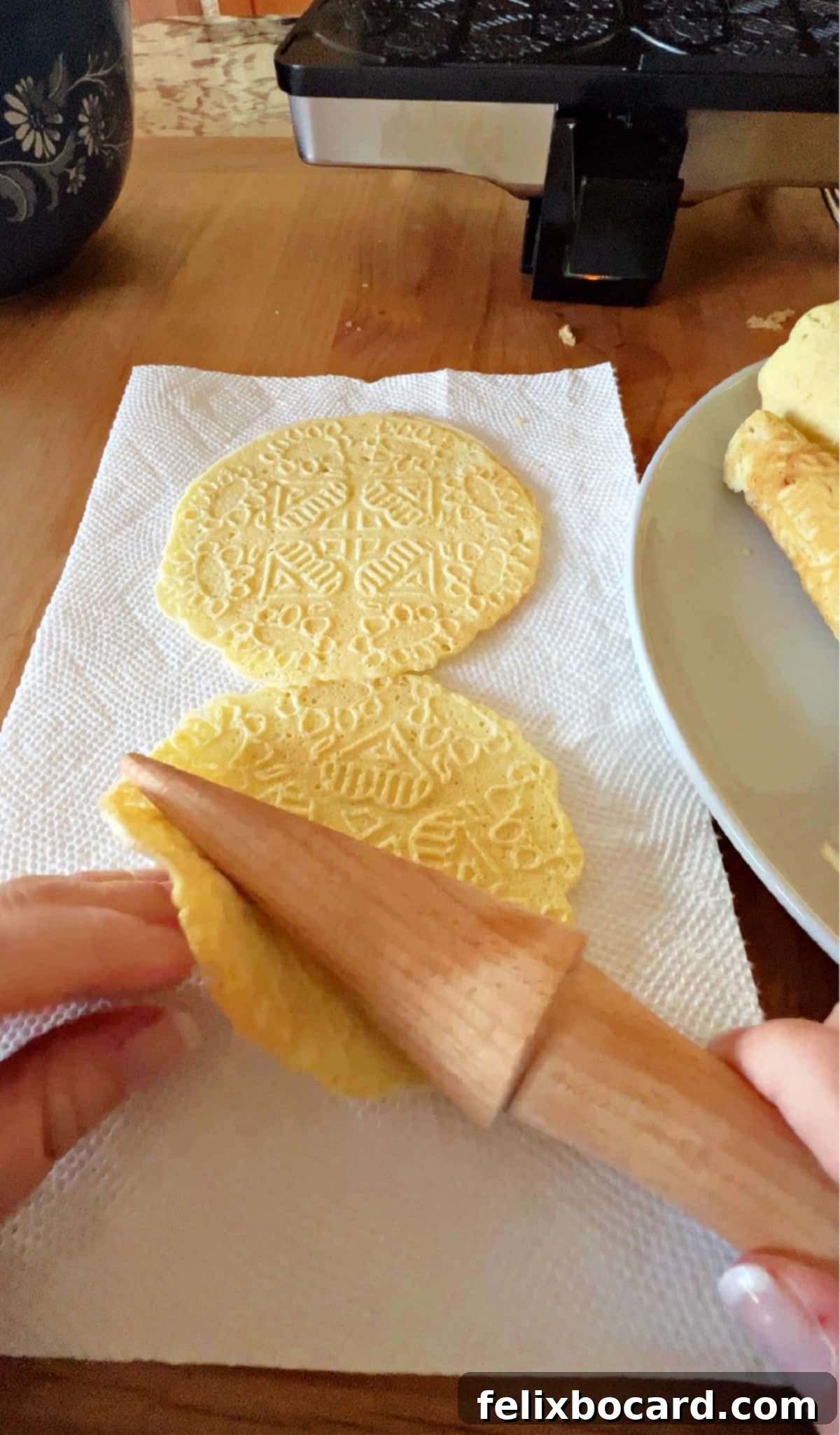Norwegian Christmas Krumkake 7 Rolling a warm Krumkake cookie with the special wooden cone tool to form its shape.